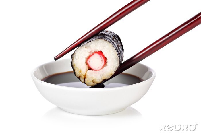 Sticker Sushi mit Stäbchen über einer Schüssel mit Sauce gehalten