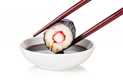 Sticker Sushi mit Stäbchen über einer Schüssel mit Sauce gehalten