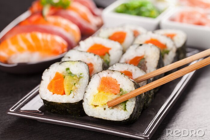 Sticker Sushi-Rollen auf einem schwarzen Teller