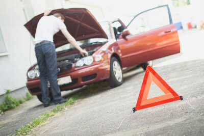 Sticker Warndreieck mit Autopanne im Hintergrund