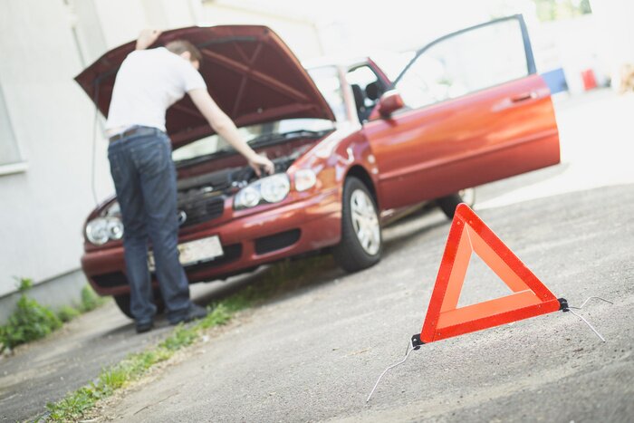 Sticker Warndreieck mit Autopanne im Hintergrund